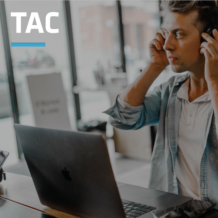 Young man sitting in front of a laptop and putting on his headset