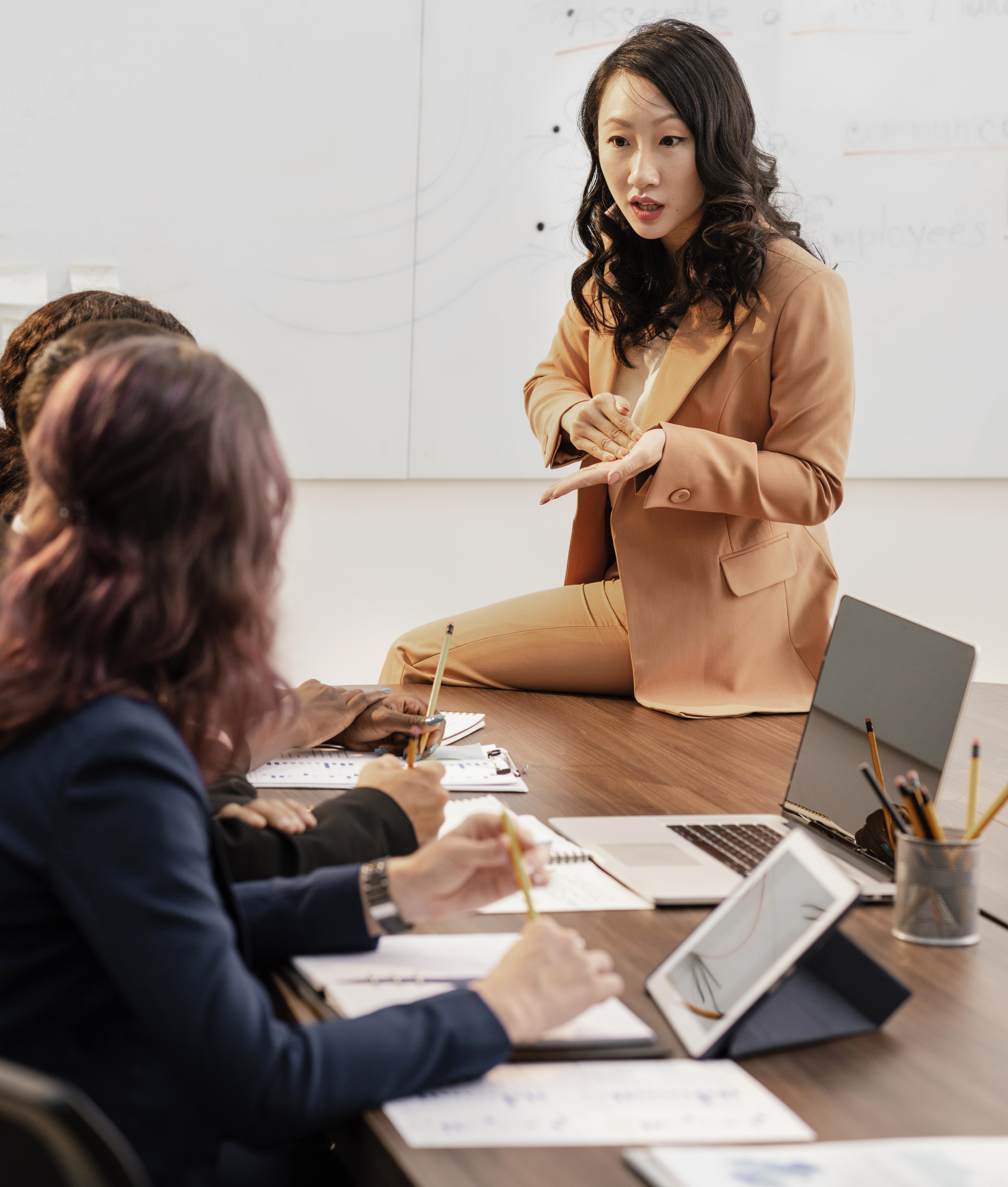Woman in HR position sitting on a table and  explaining assessment process 